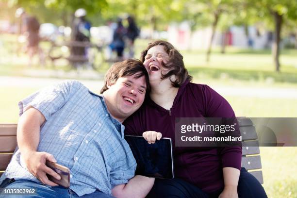 couple with down syndrome working doing selfie with mobile phone - physical disability stock pictures, royalty-free photos & images