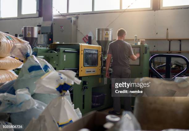 an operator works at manual station on an automated assembly line - labor intensive production line imagens e fotografias de stock