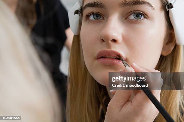 model having makeup applied - lipgloss stock-fotos und bilder