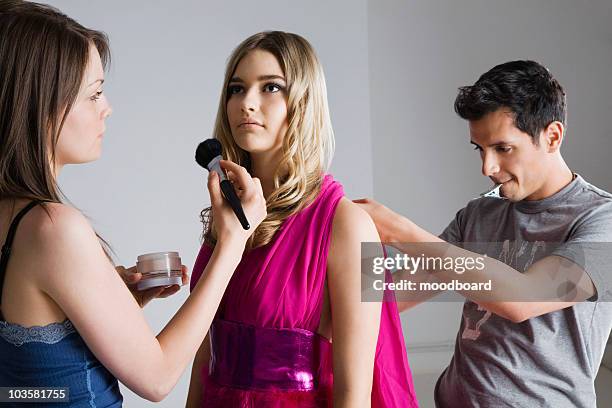 designer and makeup artist preparing model for photo shoot - backstage photography stock-fotos und bilder