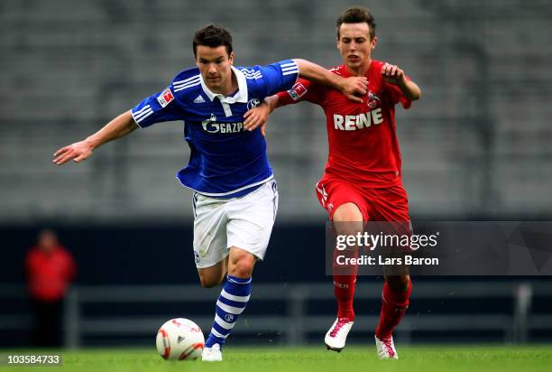 Alexander Baumjohann of Schalke is challenged by Adam Matuschyk of Koeln during a friendly match between FC Schalke 04 and 1. FC Koeln at Veltins...