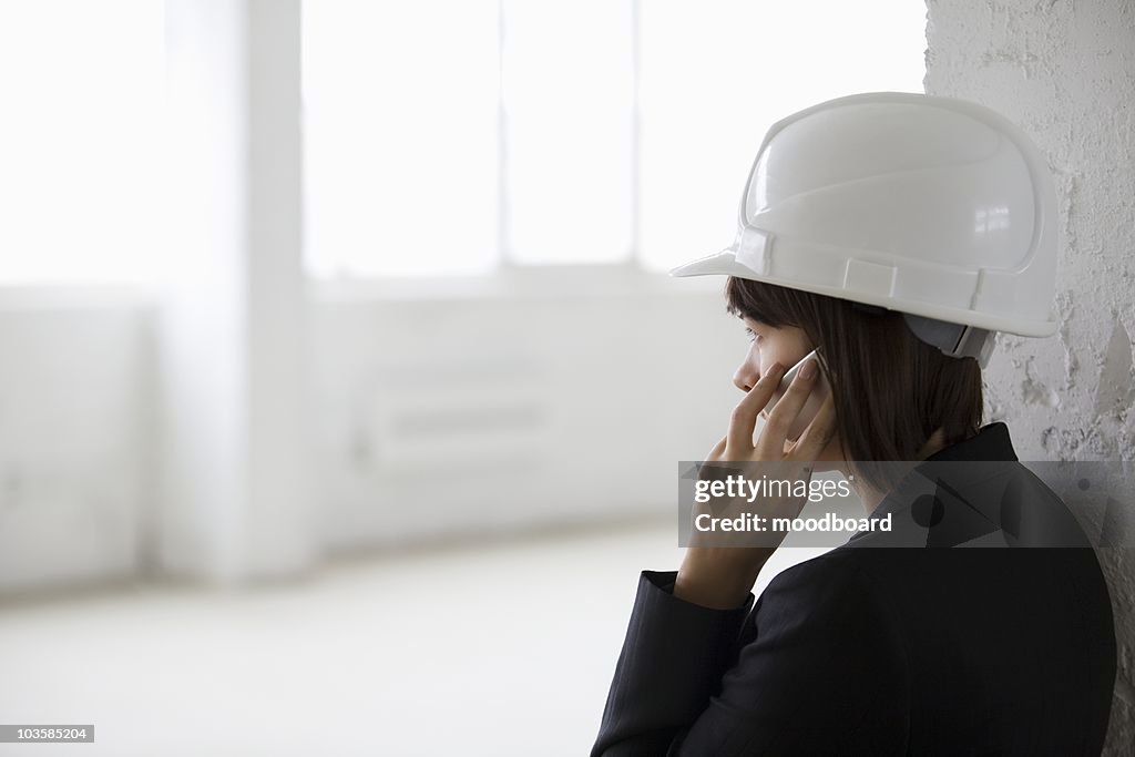 Business woman on mobile phone in empty warehouse