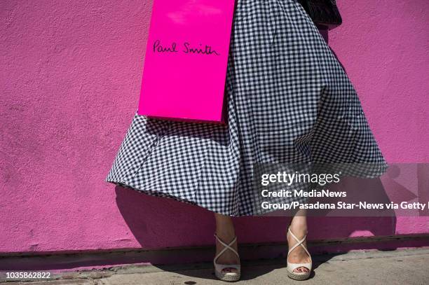 Woman poses at Paul Smith's flagship store on Melrose Avenue in Los Angeles as painters finish covering up graffiti that read "Go F... Ur Selfie" on...