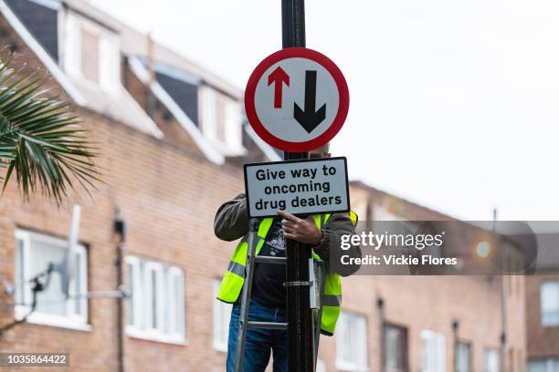 Community activists from the Columbia Road Cartel' erect hoax 'Give way to oncoming drug dealers' road signs as part of the anti drugs street art...