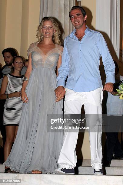 Prince Nikolaos and his fiance Tatiana Blatnik wave from the steps of the Poseidon Hotel as they attend their pre-wedding reception on August 24,...
