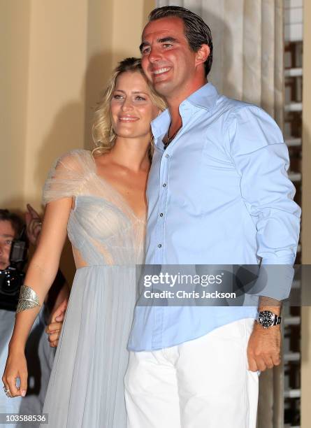 Prince Nikolaos and his fiance Tatiana Blatnik wave from the steps of the Poseidon Hotel as they attend their pre-wedding reception on August 24,...
