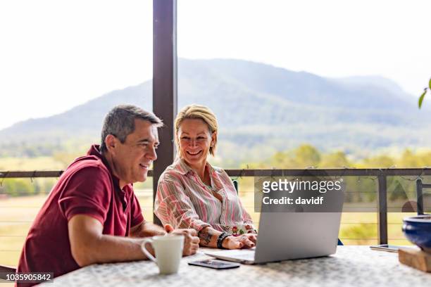 coppia che usa un computer nella loro fattoria - scena rurale foto e immagini stock