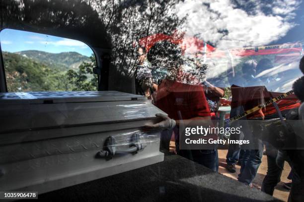 Workers place inside a vehicle a coffin of a victim killed by a landslide on September 19, 2018 in Itogon, Benguet province, Philippines. Dozens of...