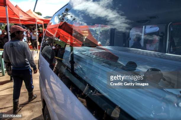 Workers place inside a vehicle a coffin of a victim killed by a landslide on September 19, 2018 in Itogon, Benguet province, Philippines. Dozens of...