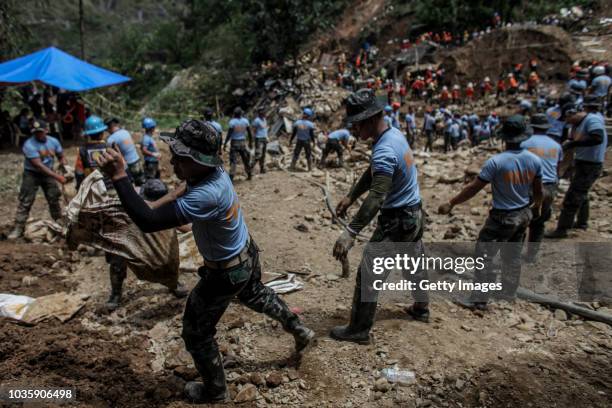 Filipino rescuers dig at the site where people were believed to have been buried by a landslide on September 19, 2018 in Itogon, Benguet province,...