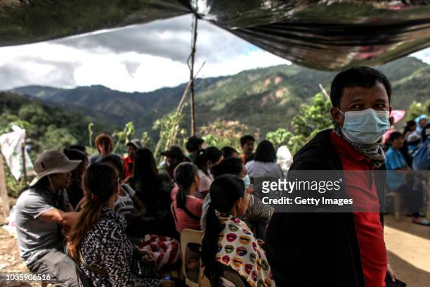 Families wait for the bodies of their loved ones who were killed by a landslide on September 19, 2018 in Itogon, Benguet province, Philippines....