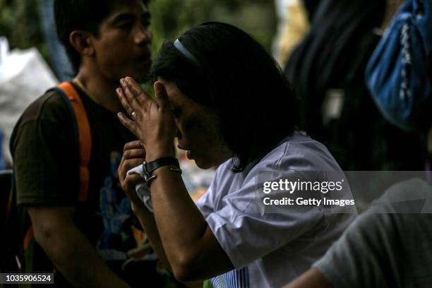 Zeny Accangan weeps as she waits for the body of her brother, Harvey Gumuwang, who is a miner and was killed by a landslide on September 19, 2018 in...