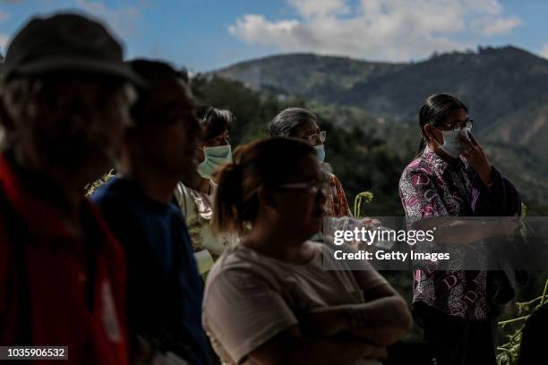 Families wait for the bodies of their loved ones who were killed by a landslide on September 19, 2018 in Itogon, Benguet province, Philippines....