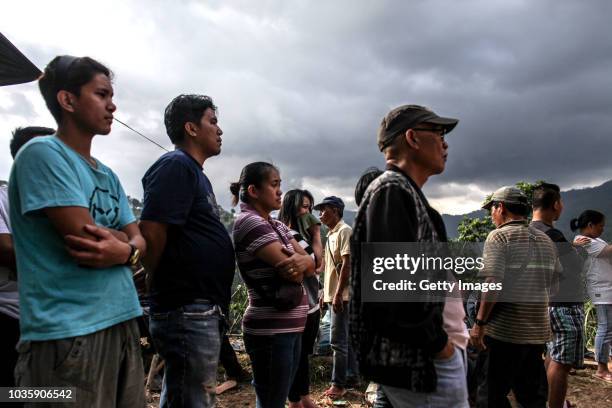 Families wait for the bodies of their loved ones who were killed by a landslide on September 19, 2018 in Itogon, Benguet province, Philippines....