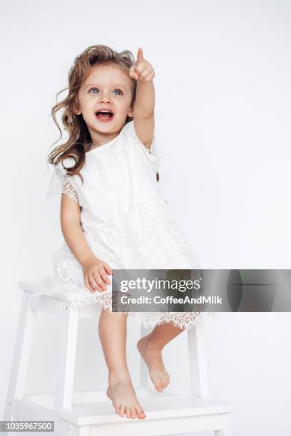 cute little girl in white dress smiling on camera - 3 years brunette female alone caucasian stock pictures, royalty-free photos & images