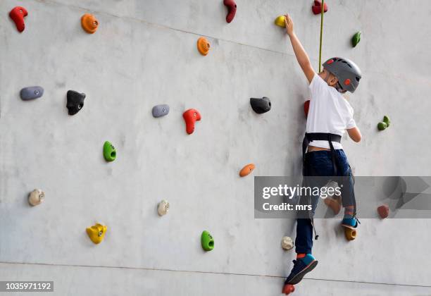 boy climbing up wall - child climbing stock pictures, royalty-free photos & images