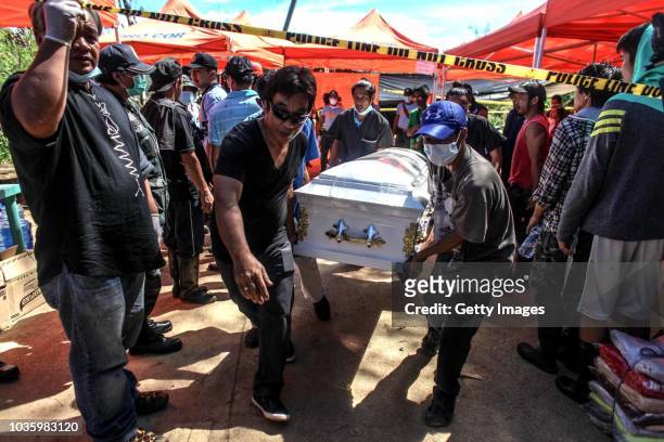 Workers carry a coffin of a victim killed by a landslide on September 19, 2018 in Itogon, Benguet province, Philippines. Dozens of people are feared...