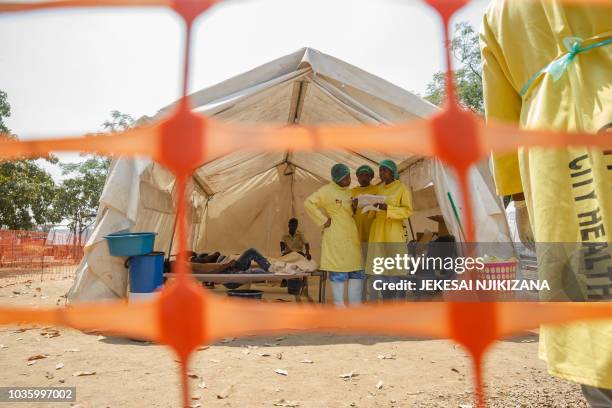Medical staff give treatment to people suffering from cholera at a medical camp set up outside the Glen View polyclinic on September 19 in Harare. -...