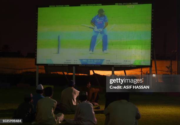 Pakistani viewers watch a big screen in a park in Karachi on September 19 showing action from an Asia Cup group cricket match between India and...