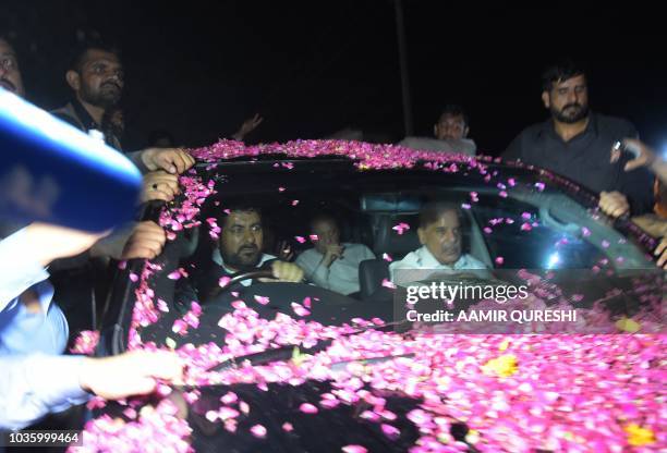 Former Pakistani Prime Minister Nawaz Sharif sits in a vehicle alongside his younger brother Shahbaz Sharif following his release from Adiala prison...