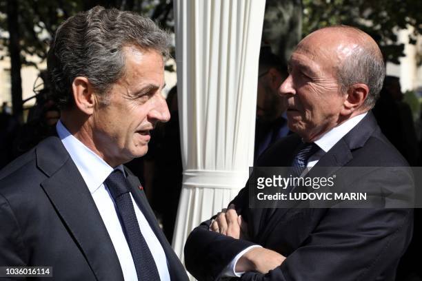 Former French President Nicolas Sarkozy talks with Interior minister Gerard Collomb as they attend the national ceremony in memory of the victims of...