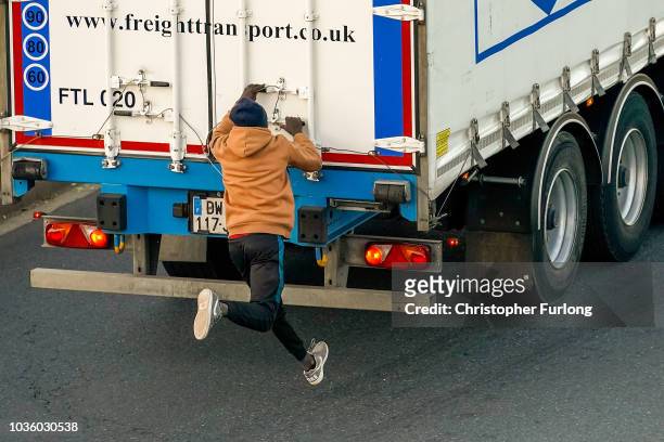 Migrants try to board a truck at Ouistreham ferry port in the hope of reaching the UK on September 11, 2018 in Ouistreham, France. After the clamp...