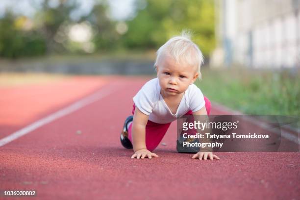 little toddler baby boy, playing on stadium, prepare for run - baby run stock pictures, royalty-free photos & images