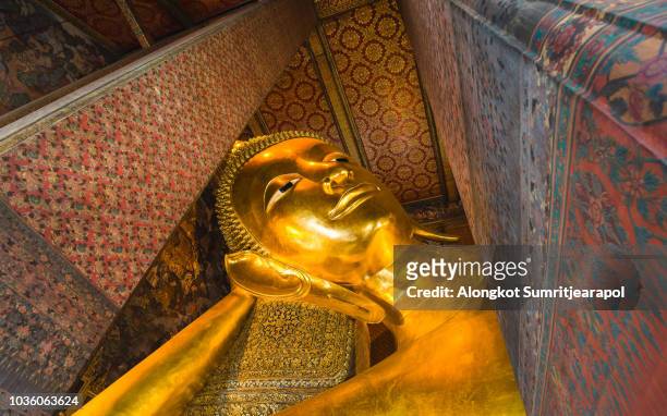 reclining buddha gold statue face. wat pho, bangkok, thailand - buddha face stock pictures, royalty-free photos & images