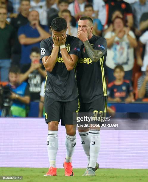 Juventus' Portuguese forward Cristiano Ronaldo cries next to Juventus' Italian midfielder Federico Bernardeschi after receiving a red card during the...