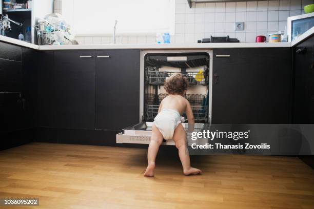 1 year old boy in front of a dishwasher - dishwasher front stockfoto's en -beelden