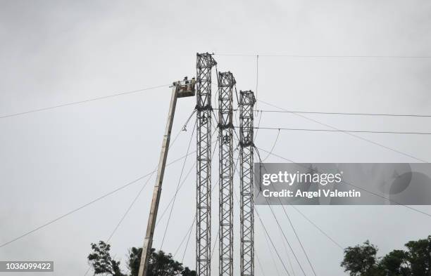 Electric company crews work on electrical towers in a clearing atop a mountain on September 19, 2018 in Patillas, Puerto Rico. Personnel has been...