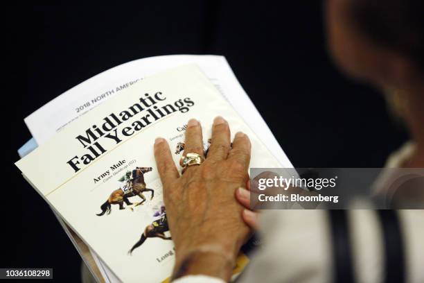 Sale attendee holds an auction program during the 75th annual Keeneland September Yearling Sale at Keeneland Racecourse in Lexington, Kentucky, U.S.,...