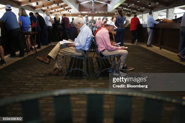 Prospective buyers study sale programs during the 75th annual Keeneland September Yearling Sale at Keeneland Racecourse in Lexington, Kentucky, U.S.,...