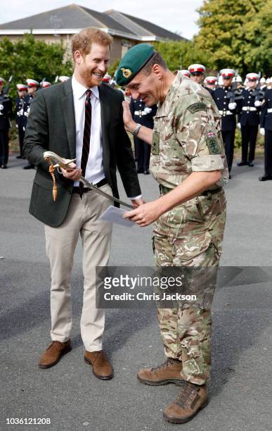 Prince Harry, Duke of Sussex is presented with the Sword of honour as he visits The Royal Marines Commnado Training Centre on September 13, 2018 in...