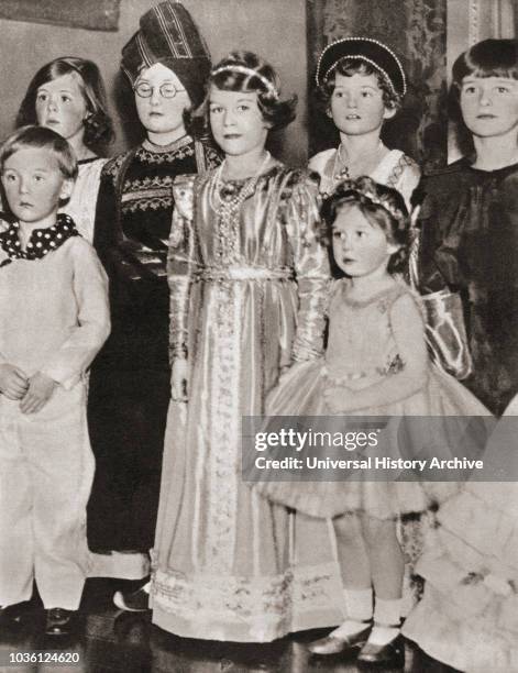 Princess Elizabeth of York, in Tudor Gown and Princess Margaret in fairy costume, at a fancy dress party in 1934. Princess Elizabeth of York, future...