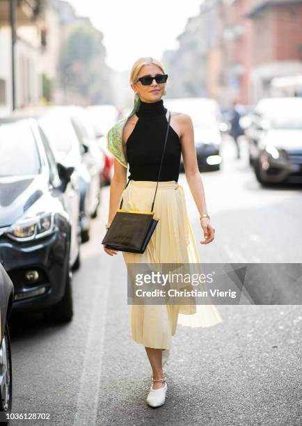 Caroline Daur wearing yellow skirt, black top, scarf in her hair is seen outside Jil Sander during Milan Fashion Week Spring/Summer 2019 on September...