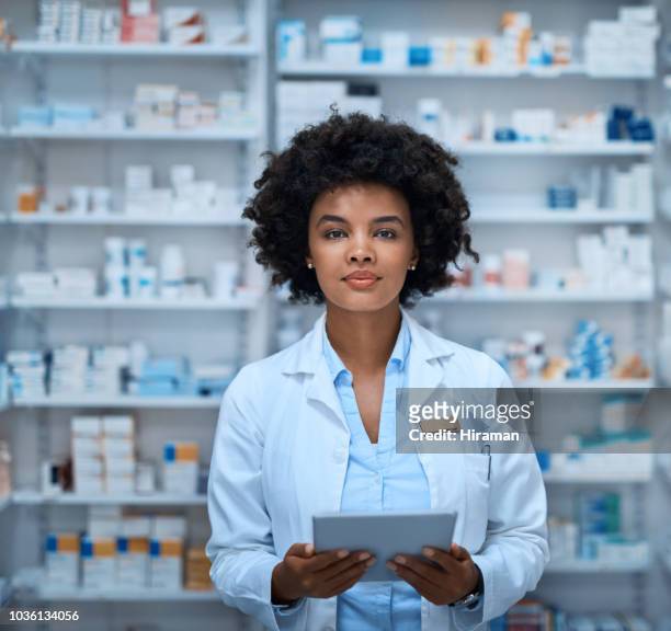 digitale technologie hält sich mit meinem pharmazeutischen aufgaben und pflichten - female pharmacist with a digital tablet stock-fotos und bilder