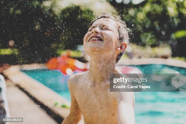 boy splashing at poolside - boy swimming stock-fotos und bilder