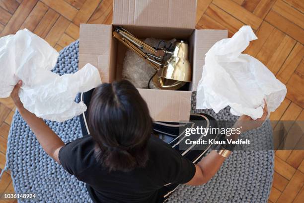 young woman opening box with lamp at home - online shopping opening package stock pictures, royalty-free photos & images