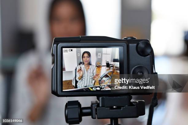 female influencer recording make-up tip videos for her blog - bloggen stock-fotos und bilder