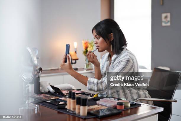 female influencer recording make-up tip videos using smartphone, for her blog - one woman only videos stock pictures, royalty-free photos & images