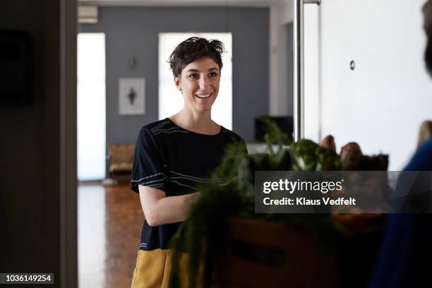 woman receiving groceries from delivery person - woman entering home stock pictures, royalty-free photos & images