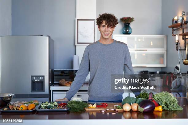 portrait of male food vlogger making video while prepping vegetables in kitchen - white chopping board stock pictures, royalty-free photos & images