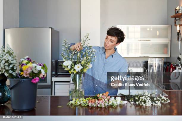 female florist organising flowers for customer from home - flower arrangement stock pictures, royalty-free photos & images
