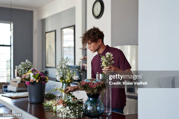 male florist organising flowers for customer from home - vulnerable species stock photos et images de collection