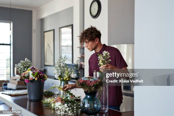 male florist organising flowers for customer from home - maroon flowers stock pictures, royalty-free photos & images