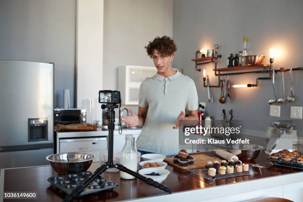 male vlogger making video while baking in kitchen - cooking on camera stock-fotos und bilder