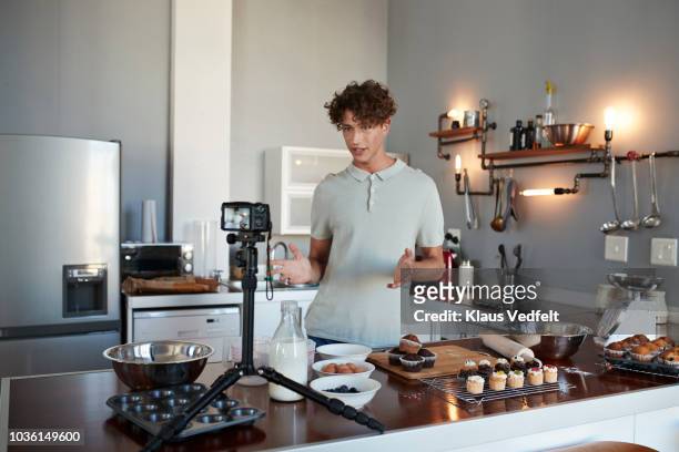 male vlogger making video while baking in kitchen - man facing camera stock pictures, royalty-free photos & images