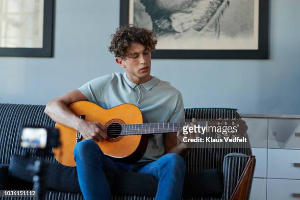 male vlogger recording guitar lesson in stylish apartment - male at home imagens e fotografias de stock