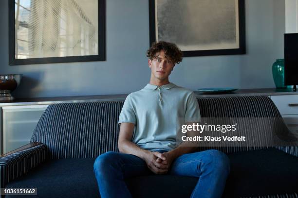portrait of young man in stylish apartment - sofa stockfoto's en -beelden